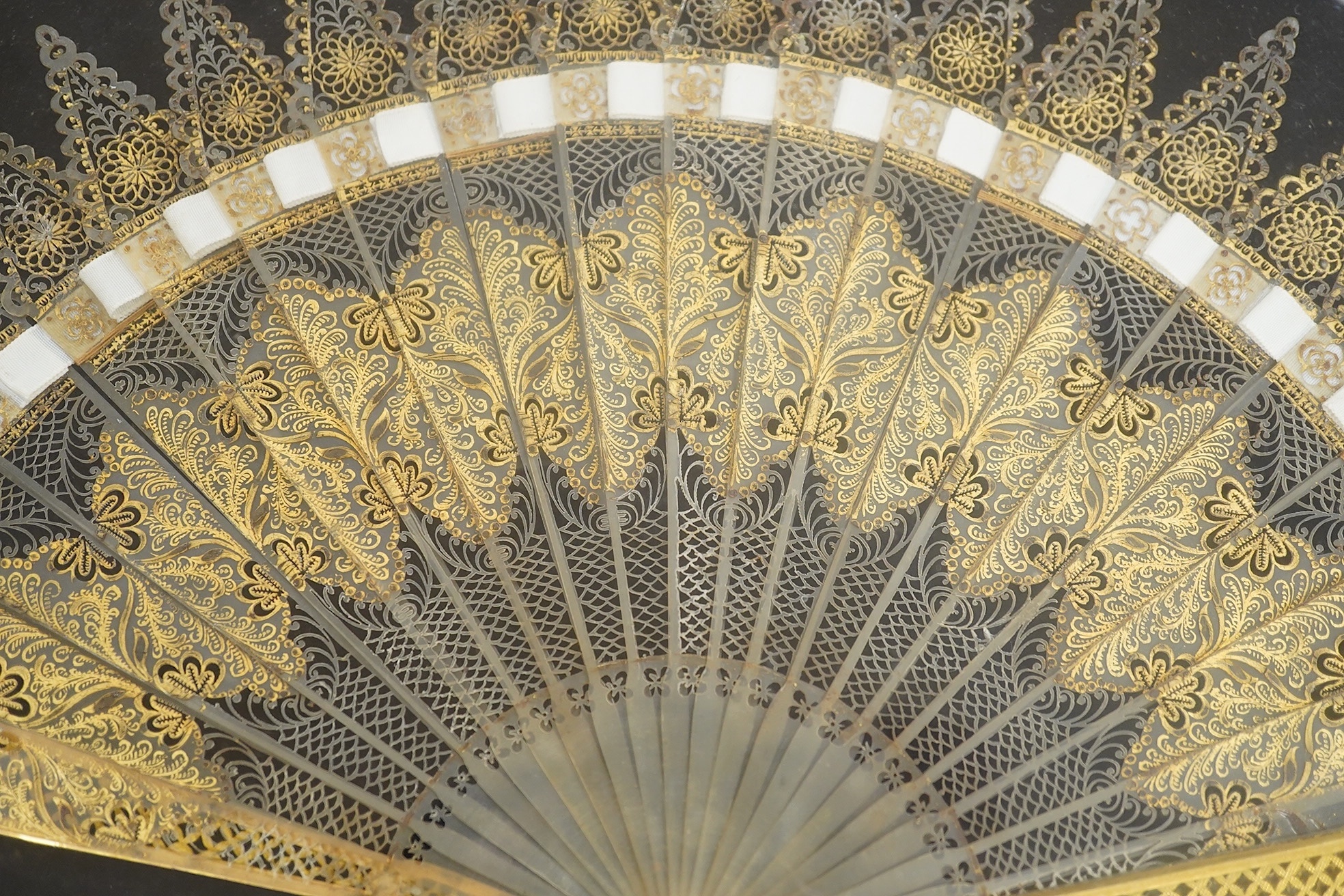 A gilt framed, fine French 1820’s blonde tortoiseshell brisé fan, originally from the Norte collection, finely pierced with hand painted gilt decoration and pierced gilt metal (possibly ormolu) guards, mounted within a g